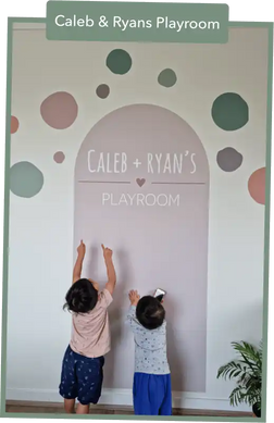 Decorative wall arch with polka dots and text reading ’Caleb + Ryan’s Playroom’