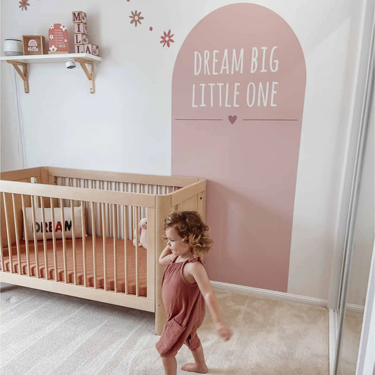 Natural wooden crib with slatted sides.